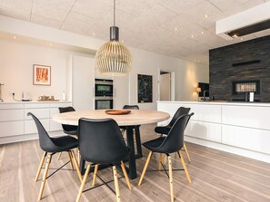 Una cocina moderna con una isla central, armarios blancos y un salpicadero oscuro.