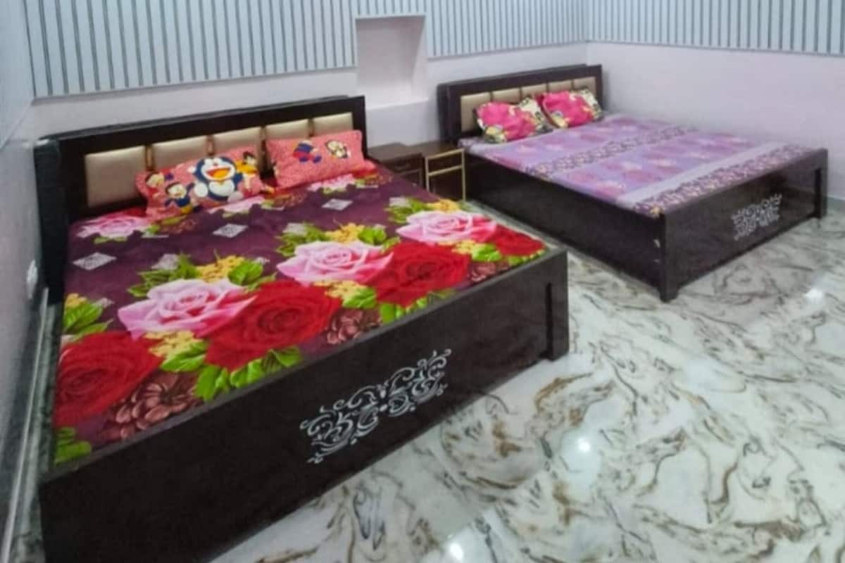 A bedroom with two beds, a ceiling fan, and a marble floor.