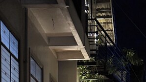 A building with a sign for 'CozyNook Boutique Rooms,' a gated entrance, and two parked motorcycles. - CozyNook Boutique Homestay (Xuan Huong - Da Lat)