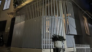 A multi-story building with balconies, a gated entrance, and potted plants. - CozyNook Boutique Homestay (Xuan Huong - Da Lat)