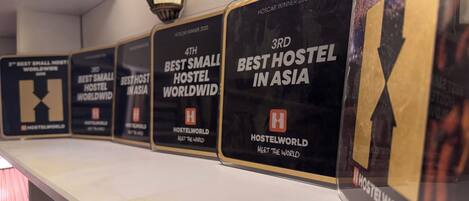 A row of award plaques on a wall, each with text indicating rankings for hostel accommodations.
