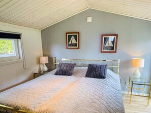 A bedroom with a bed, two nightstands, two lamps, and two framed pictures on the wall. - 4 Star Holiday Home in Nassjo (Nassjo)