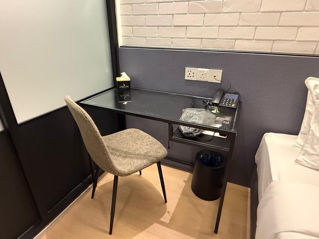 A small room with a desk, chair, and a bed.