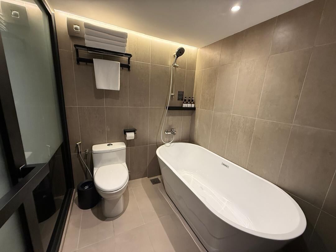 A modern bathroom with a toilet, a bathtub, and a shower.