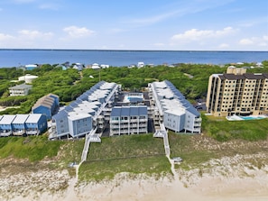 A coastal hotel with multiple buildings, a beach access area, and a view of the ocean.