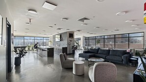 En rummelig lobby med et moderne køkkenområde, siddepladser og store vinduer med udsigt.