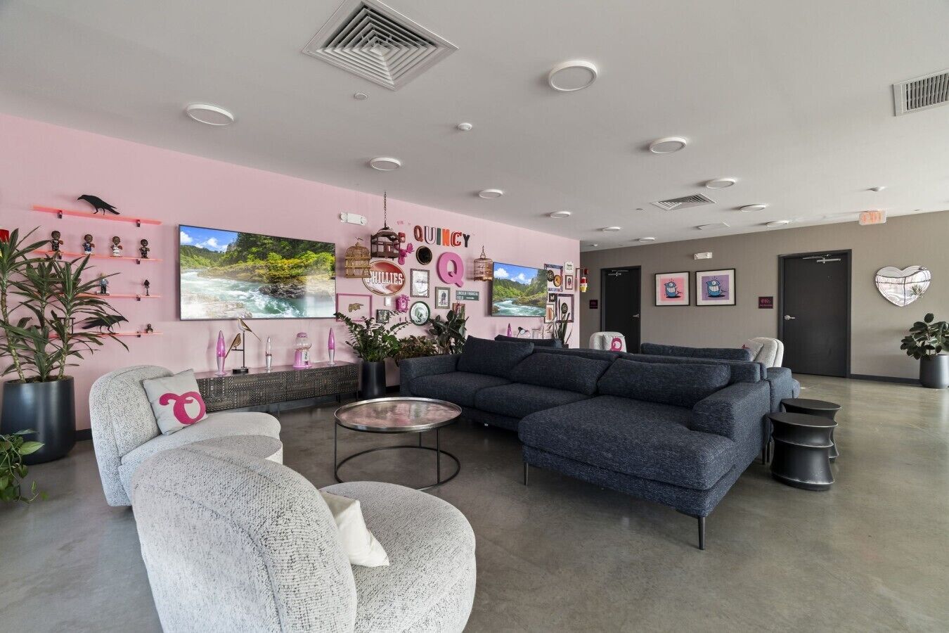 A modern living room with a sectional sofa, a round coffee table, and a large window with a view of a river.