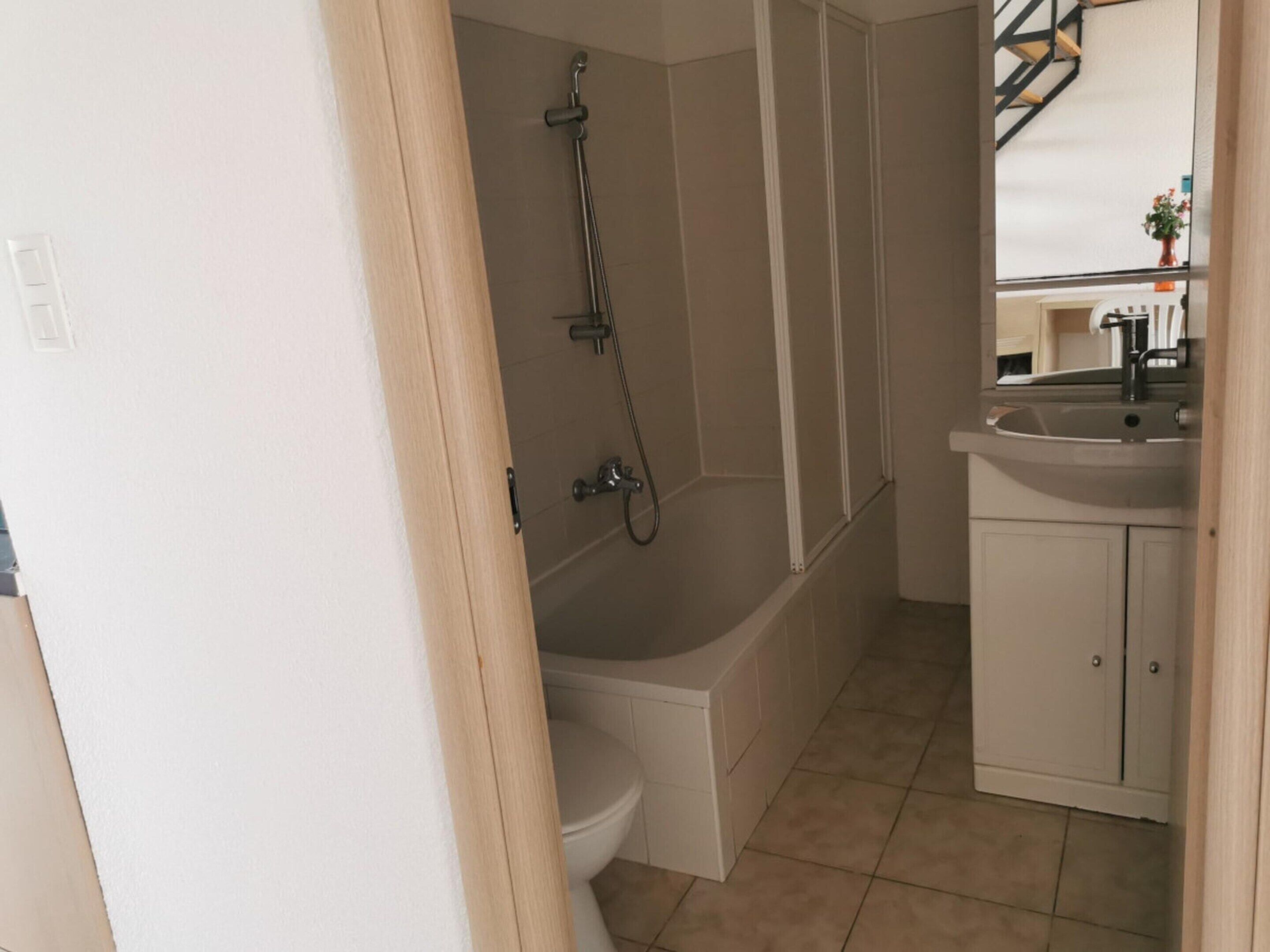 Une salle de bain comprenant des toilettes, une baignoire, une douche et un lavabo.