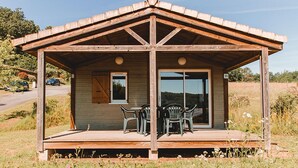 A wooden cabin with a covered porch, a sliding glass door, and a number '24' sign. - Spacious Cottage for 6 in Marminiac (Marminiac)
