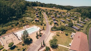 An aerial view of a residential area with houses, solar panels, a swimming pool, and a road. - Spacious Cottage for 6 in Marminiac (Marminiac)