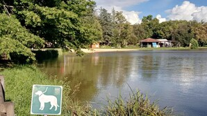 A calm lake with a dog park sign, surrounded by trees and a small building. - Spacious Cottage for 6 in Marminiac (Marminiac)