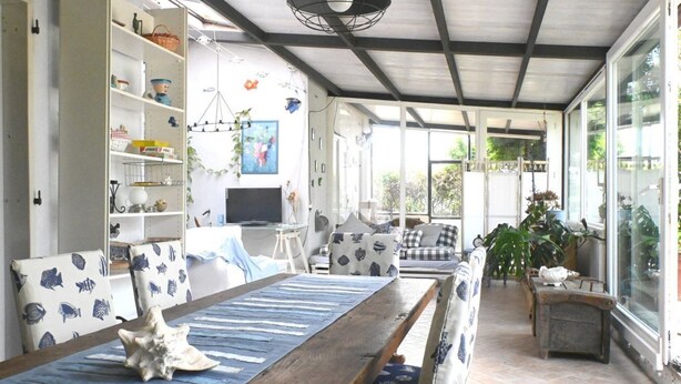 A sunlit room with a wooden table, patterned chairs, a bookshelf, and a television. - SE257 - Montemarciano, one-bedroom apartment with garden and veranda (Montemarciano)