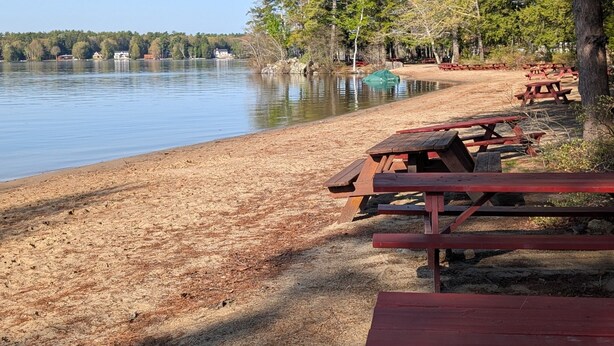 A lakeside picnic area with benches and a clear view of the water. - Charming Home Near Lake Winnipesaukee Beach Access 3 Bedroom Home (Moultonborough)