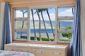 A room with a large window, a bed, and a dresser. - Menehune Shores, #206 2 Bedroom Condo (Kihei)
