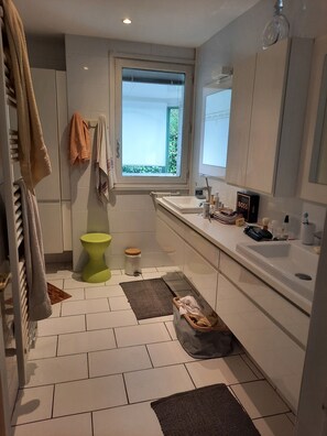 Ein modernes Badezimmer mit Toilette, Waschbecken und Spiegel.