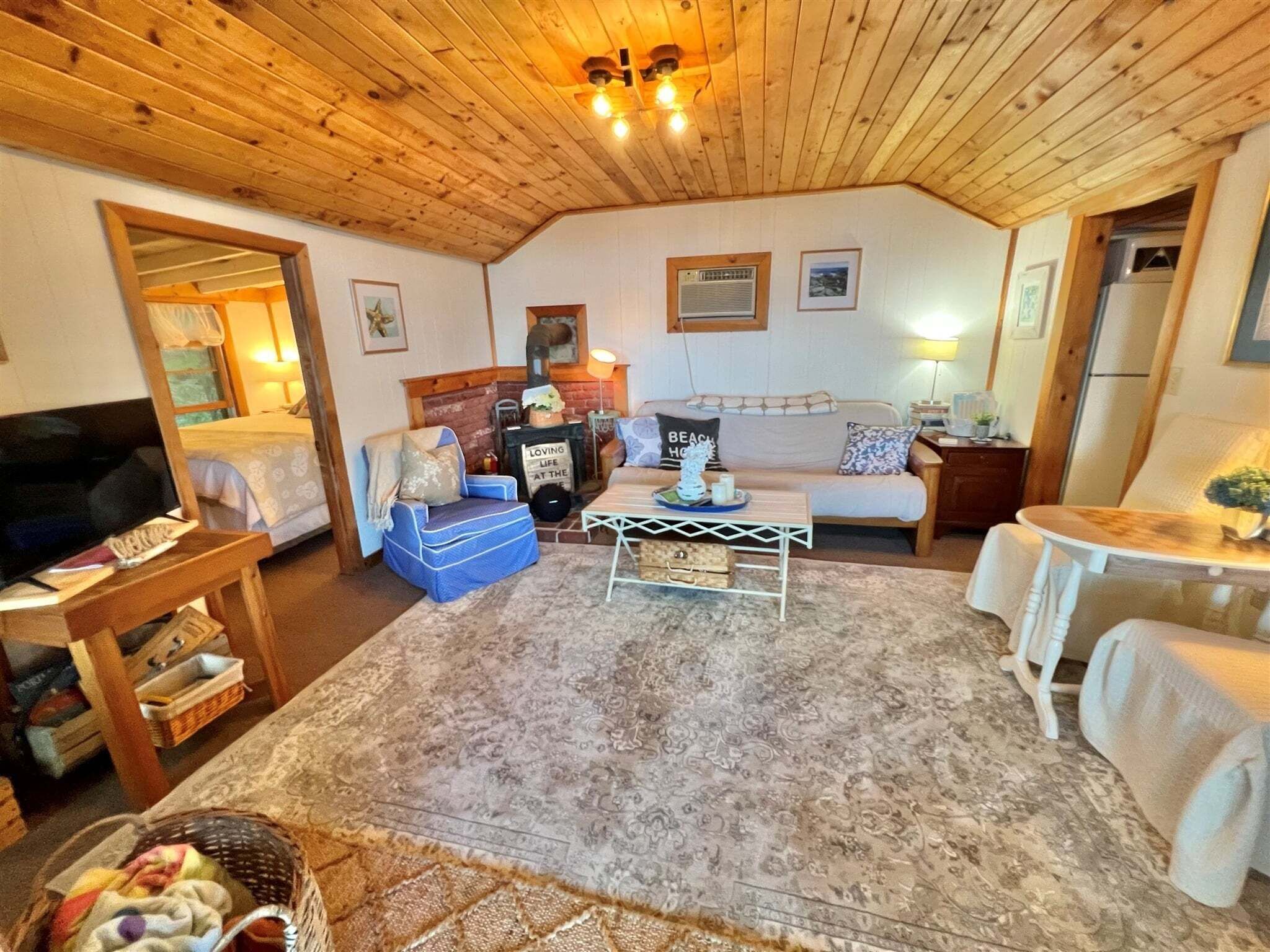 A cozy living room with a fireplace, a sofa, a TV, and a dining area.