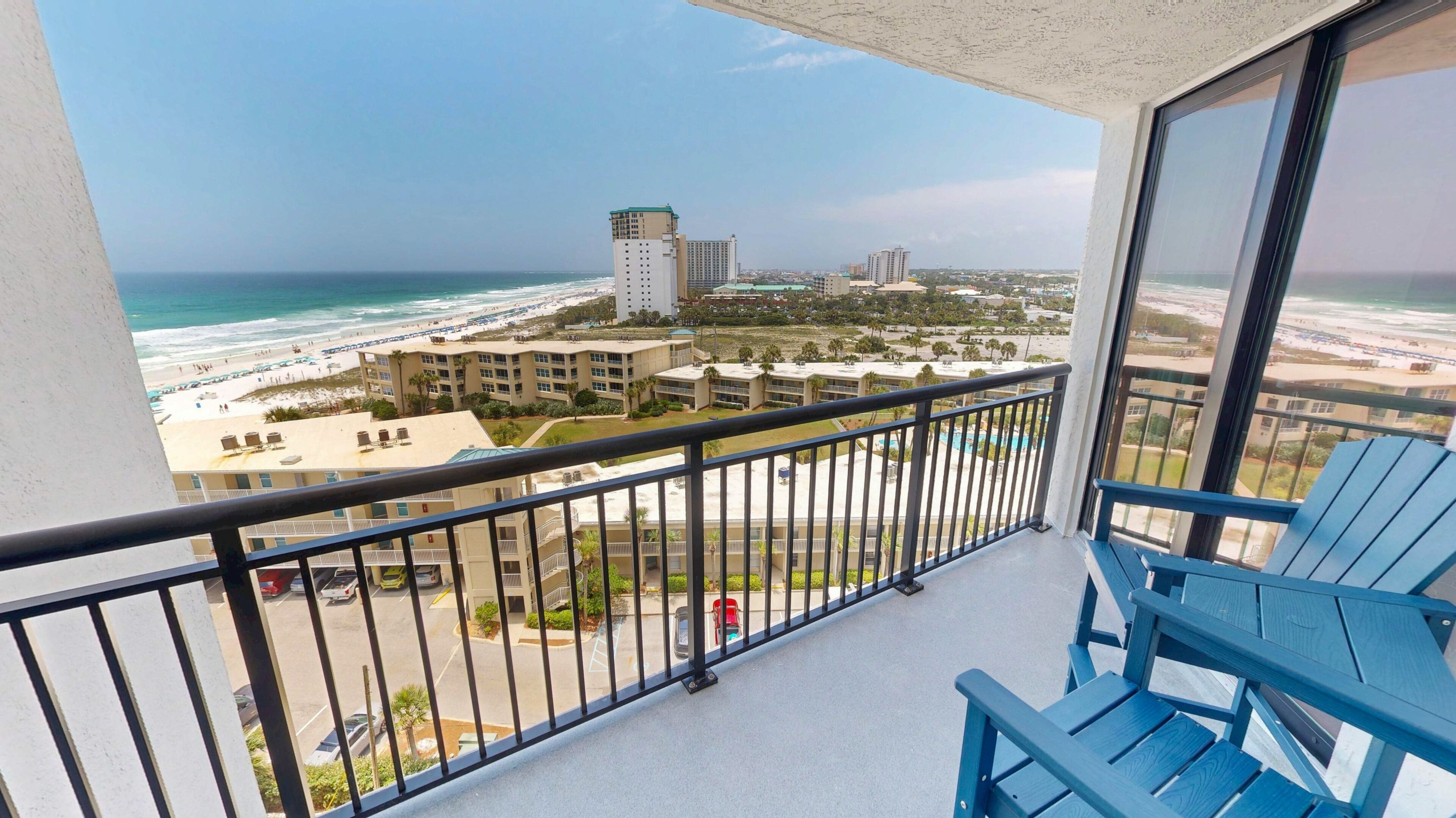 A balcony with a view of a beach and buildings.