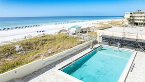 Una piscina con vista despejada a la playa y al océano.