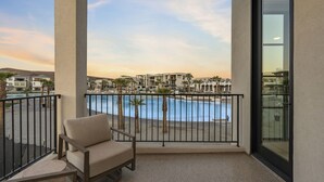 A balcony with a view of a pool and resort buildings. - Barefoot Beach House A 3 Bedroom Townhouse (St. George)