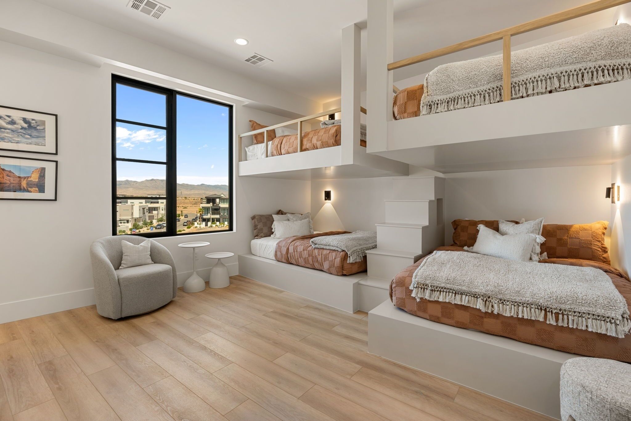 Une chambre moderne avec une grande fenêtre, un canapé, un lit et un lit superposé.