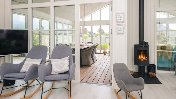 Un interior moderno con chimenea, mecedoras y televisor.