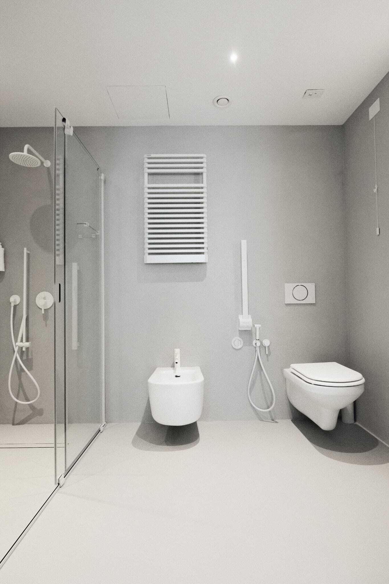 Un baño moderno con cabina de ducha de vidrio, inodoro y bidé.