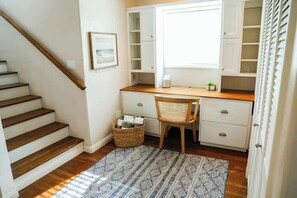 Ein Arbeitszimmer mit Schreibtisch, Stuhl und Stauraumschränken.