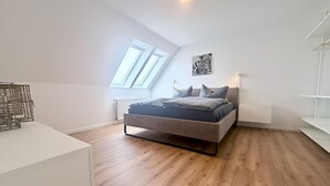 A modern bedroom with a loft bed, skylight, and a white wardrobe. - City-Loft Lingen Apartment 3 in the heart of Lingen (Lingen (Ems))