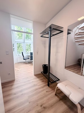 A modern room with a bench, a pull-up bar, a large mirror, and a view of a balcony. - City-Loft Lingen Apartment 1 in the heart of Lingen (Lingen)