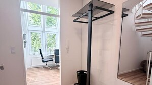 A modern room with a bench, a pull-up bar, a large mirror, and a view of a balcony. - City-Loft Lingen Apartment 1 in the heart of Lingen (Lingen)