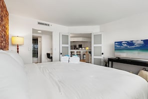 Une chambre d’hôtel avec un grand lit, une télévision et une vue sur la plage.