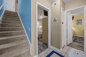 A staircase leading to a bedroom with a bed and a ceiling fan. - Beachfront Bliss | Ocean Views + Family-Friendly Yard (Emerald Isle)
