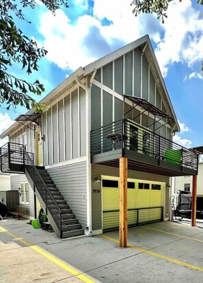 A two-story building with a balcony, a staircase, and a garage. - Chic Home w/Loft, EV Charger close to Pullman Yrds (Atlanta)