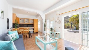 En stue med sofa, sofabord og udsigt til køkken og terrasse.