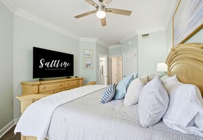 A bedroom with a bed, a television, a ceiling fan, and a dresser. - Beachfront Condo | Steps to Sand | 3 Pools (Navarre)