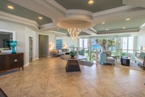 A spacious living area with a round table, a chandelier, and a view of the outdoors. - Modern Luxury Silver Beach 1605E 2 BR 2 Ba with discounted beach service for 2 (Destin)