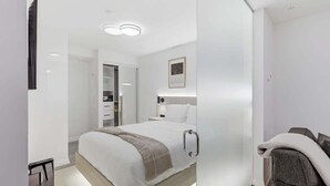 Ein modernes Schlafzimmer mit Bett, Nachttisch und Kleiderschrank.