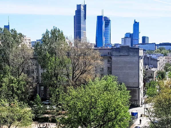 A cityscape with modern high-rise buildings, a mix of residential and commercial structures, and trees in the foreground. - Przy Klifie by Interhome (Warsaw)