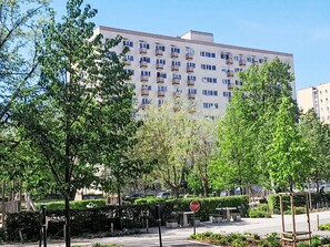 A multi-story building with balconies, surrounded by greenery and a stop sign. - Przy Klifie by Interhome (Warsaw)