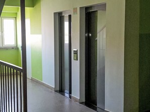An elevator with a control panel, a green wall, and a window. - Przy Klifie by Interhome (Warsaw)