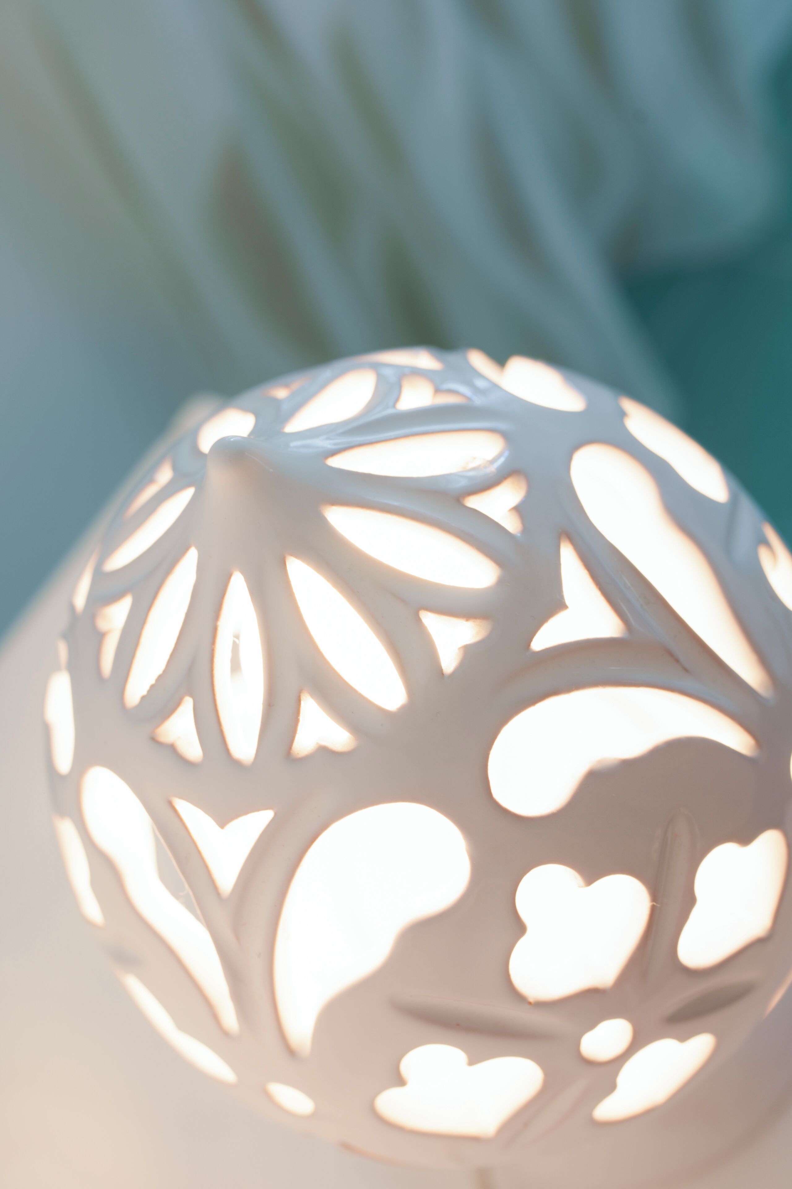 Een close-up van een bolvormige, gedetailleerd uitgesneden lamp.