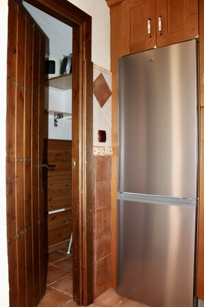 A kitchen with a stainless steel refrigerator, wooden cabinets, and a tiled backsplash. - Villa Mi Sueño | Nature | Pool & Open Skies | 3B (Málaga)