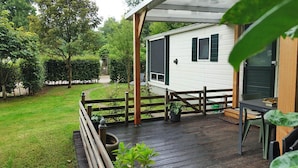 A modern house with a deck, a fenced garden, and a pathway leading to the house. - Vechtdal Chalet de Eik (Rheezerveen)
