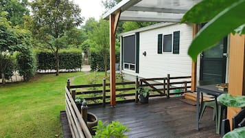 A modern house with a deck, a fenced garden, and a pathway leading to the house.