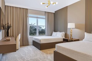 A hotel room with two beds, a desk, a lamp, and a view of the outside. - 10BR house with game room, sleeps 22 in clermont (Clermont)