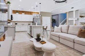 A modern kitchen with white cabinets, a central island, and pendant lighting. - 10BR house at Windsor Cay resort, sleeps 22 (Clermont)