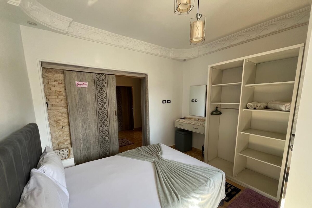 Ein Schlafzimmer mit Bett, Kleiderschrank, Badezimmer und einer Tür mit einem Verbotsschild.