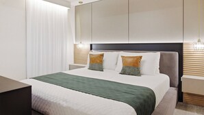 Ein modernes Hotelzimmer mit einem großen Bett, einem Nachttisch und einer Wandleuchte.