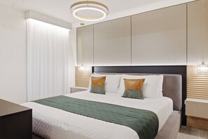 A modern hotel room with a large bed, a bedside table, a nightstand, and a wall-mounted light fixture. - 8BR house sleeps 22 near Disney area (Clermont)