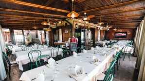 A restaurant with wooden ceilings, green chairs, and tables set for dining. - Agriturismo la Baita  (Agerola)